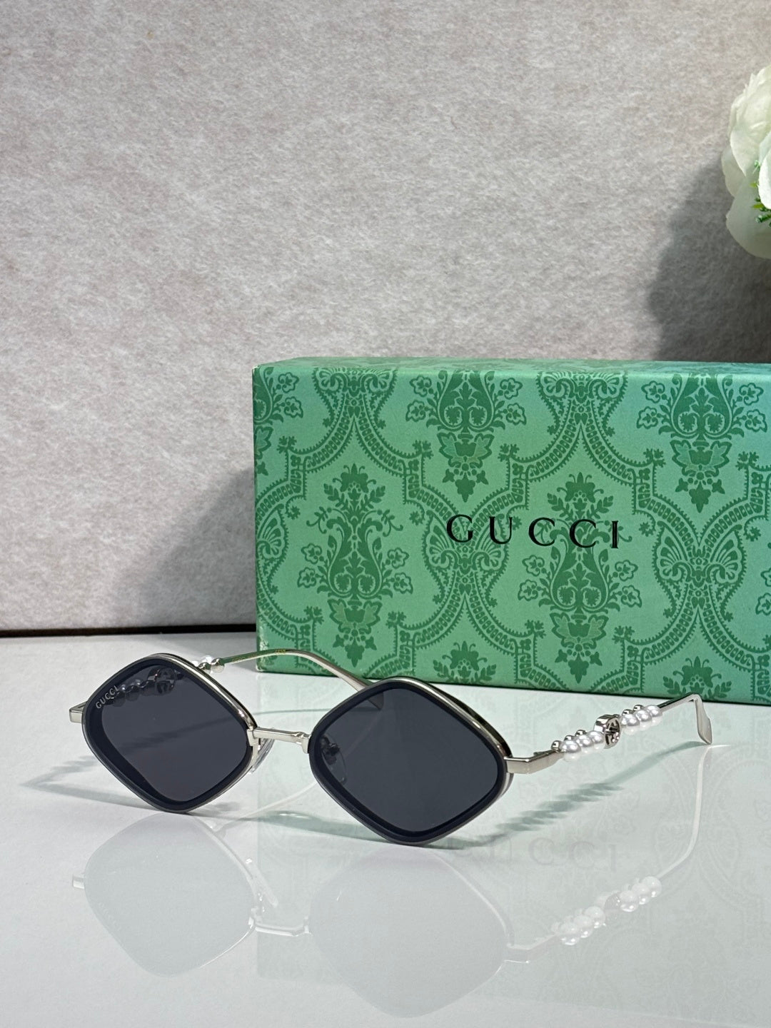 Gucci sunglasses with dark lenses and silver metal frames, arched square style