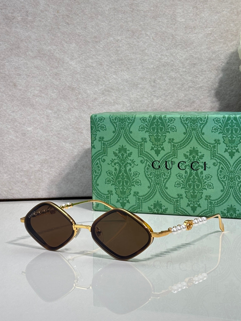 Gucci sunglasses with dark brown lenses and gold frames, black front accents