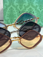 Gucci sunglasses set with gold frames, dark navy and brown lenses, stacked view