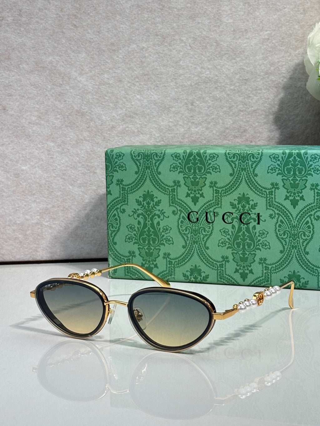 Gold oval sunglasses with gradient green lenses and decorative chain-link arms
