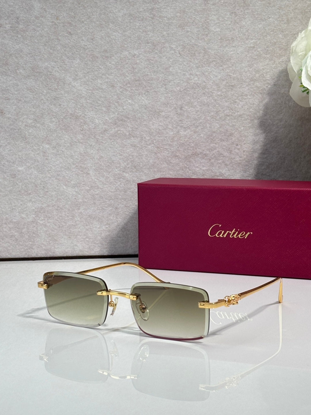 Cartier glasses with gold frame and light gray gradient lenses, square silhouette