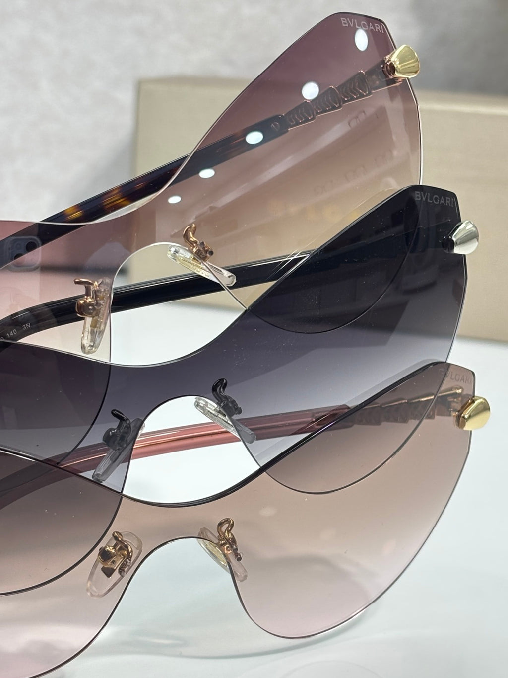 Bvlgari cat-eye sunglasses stacked together, showing tinted lenses and gold details