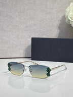 Dior sunglasses with green-tinted lenses and gold frame, green floral accents on temples