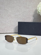 Dior sunglasses with brown lenses and gold frame, dark floral accents on temples
