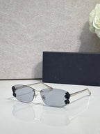 Dior sunglasses with clear lenses and dark floral accents on temples, thin metal frame