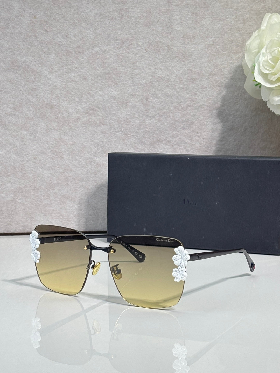 Dior sunglasses, gold frame, dark temples, yellow gradient lenses, light blue floral details