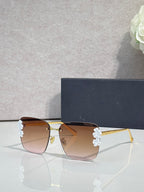 Dior sunglasses, gold frame, dark temples, pink gradient lenses, white floral accents
