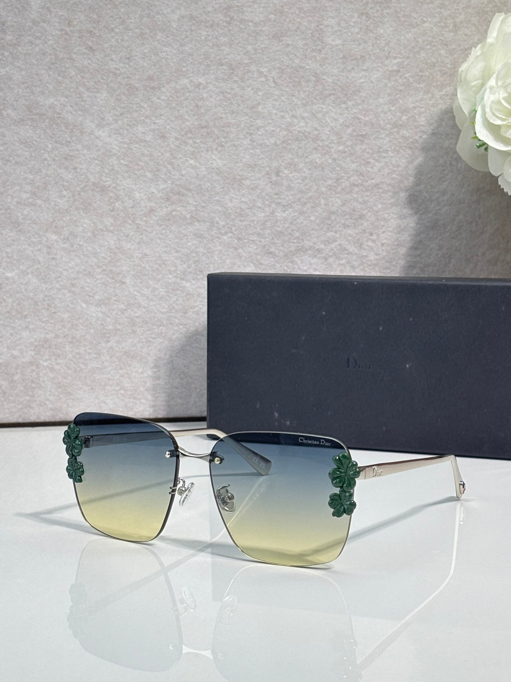 Dior sunglasses, gold frame, dark temples, pale yellow gradient lenses, green floral accents