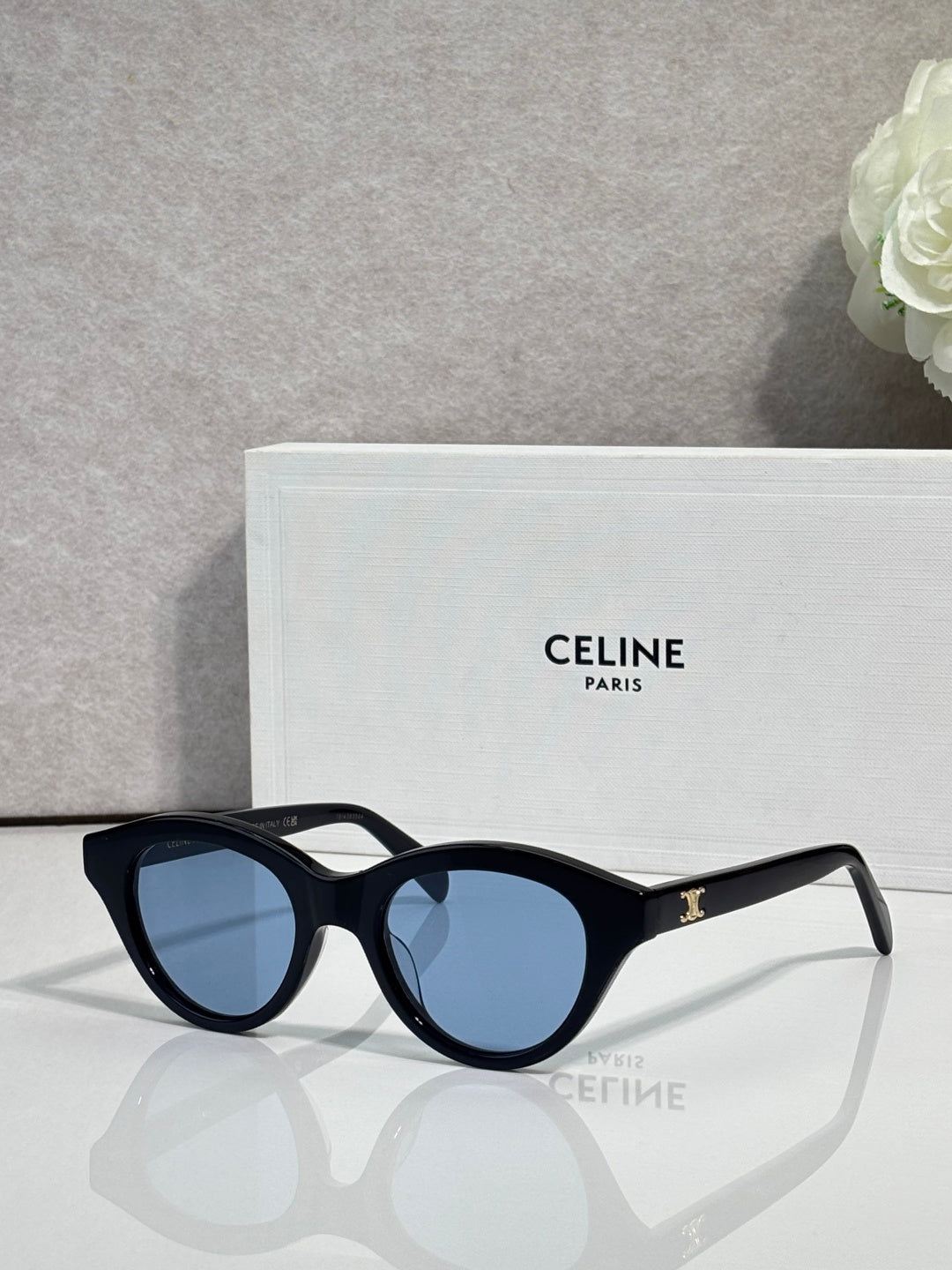 Celine sunglasses with black oval frames and blue-tinted lenses