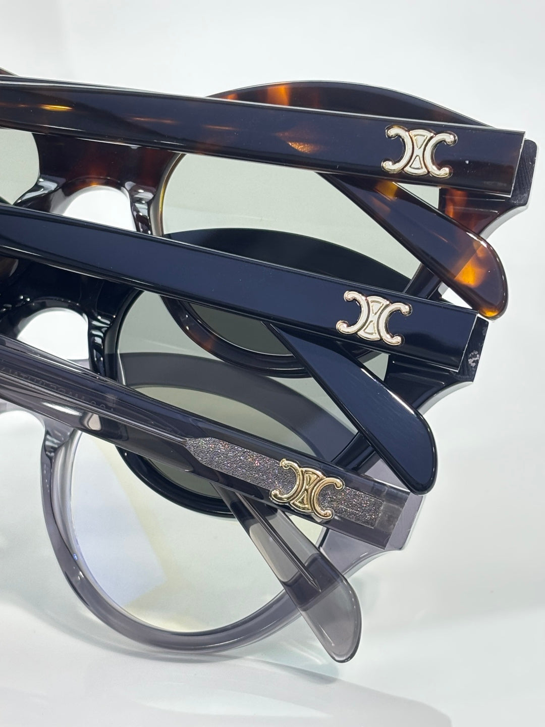 Celine sunglasses close-up: oval dark frames with gold C logo on temples
