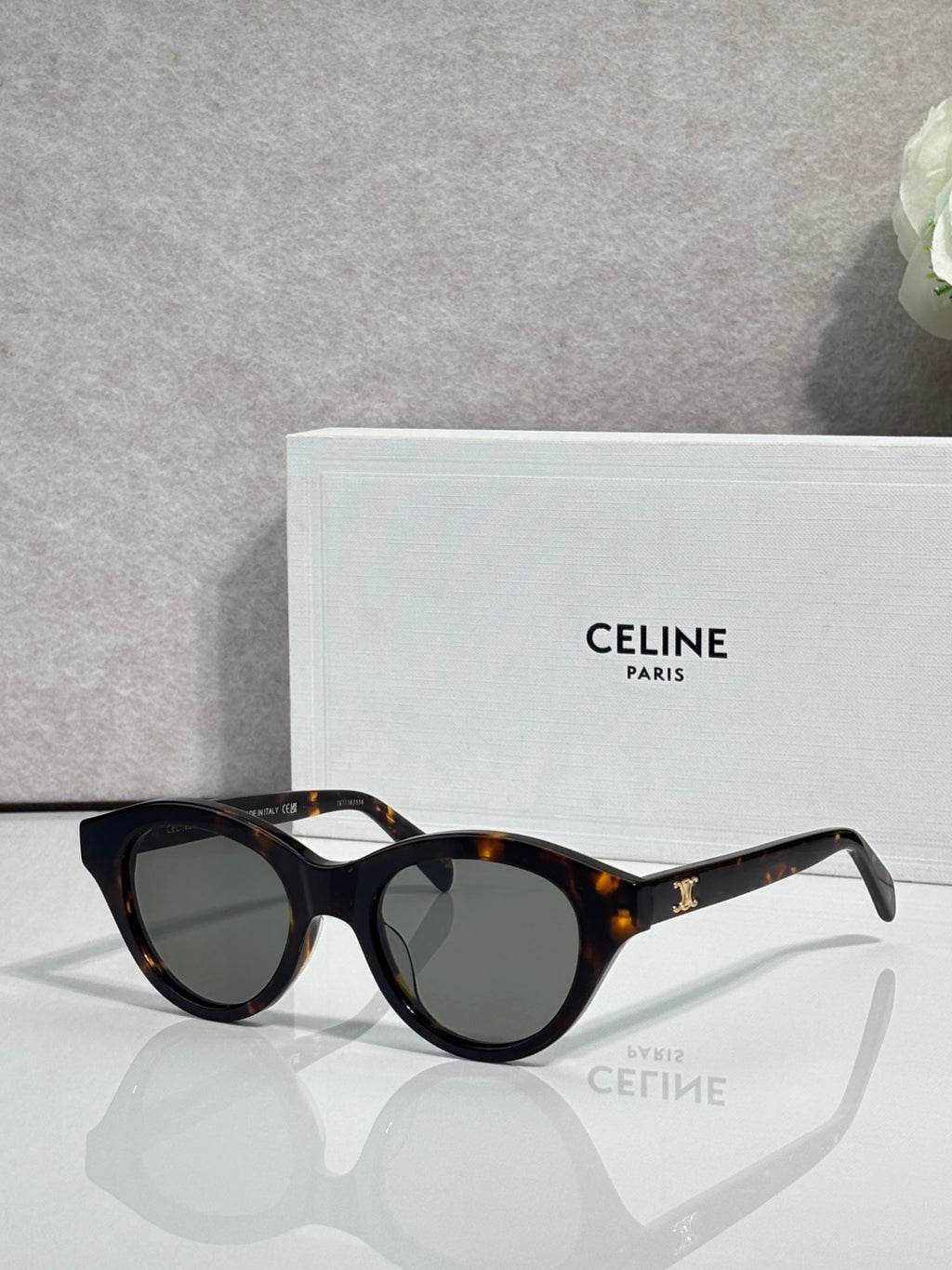 Celine sunglasses with black frames, tortoiseshell tips, and dark-tinted lenses