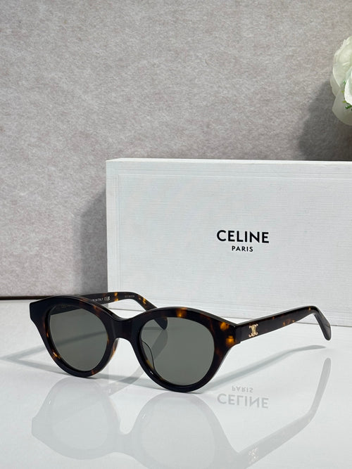 Celine sunglasses with black frames, tortoiseshell tips, and dark-tinted lenses