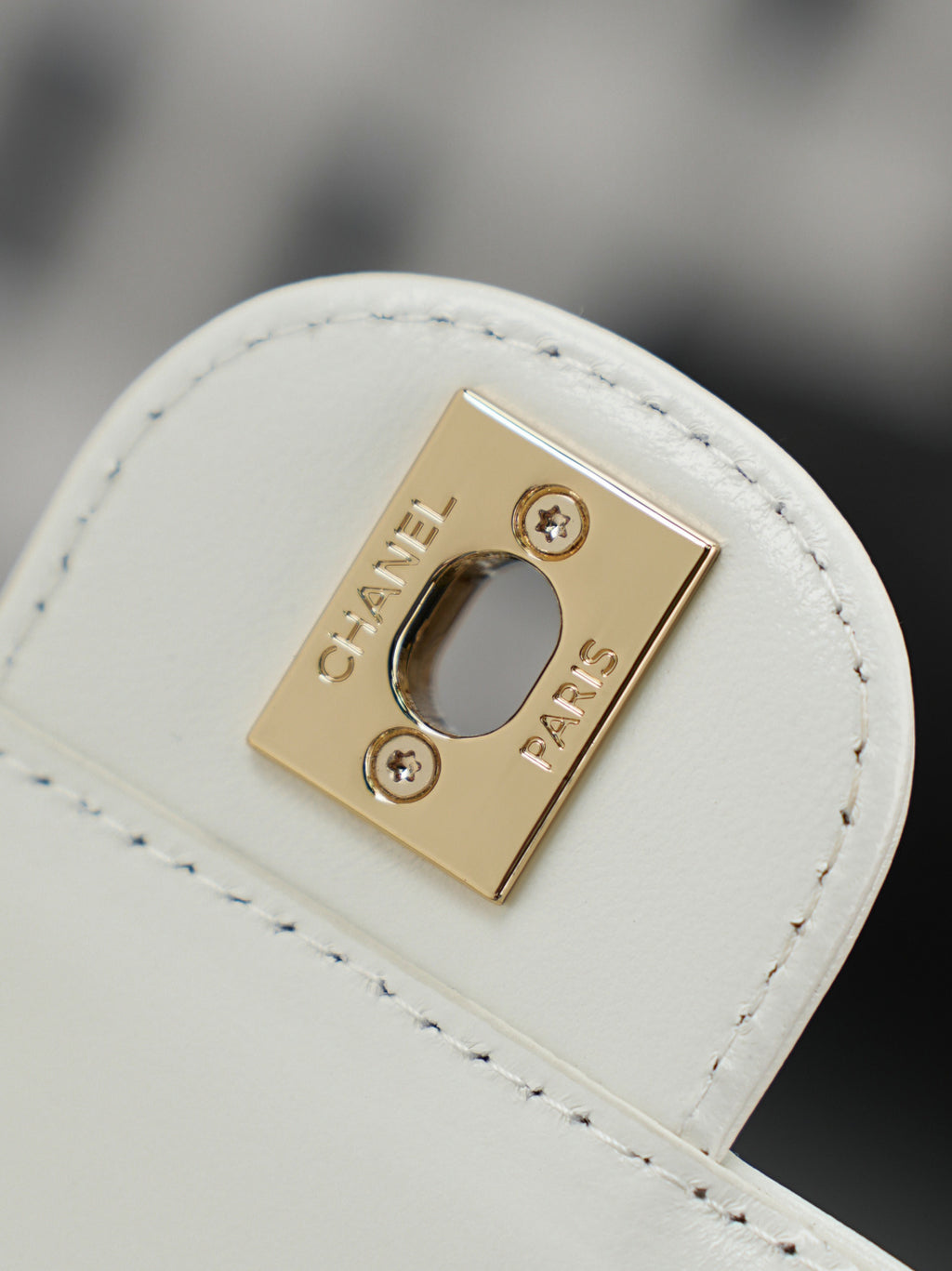 Chanel mini bag strap loop with gold-tone logo plaque and snap closure