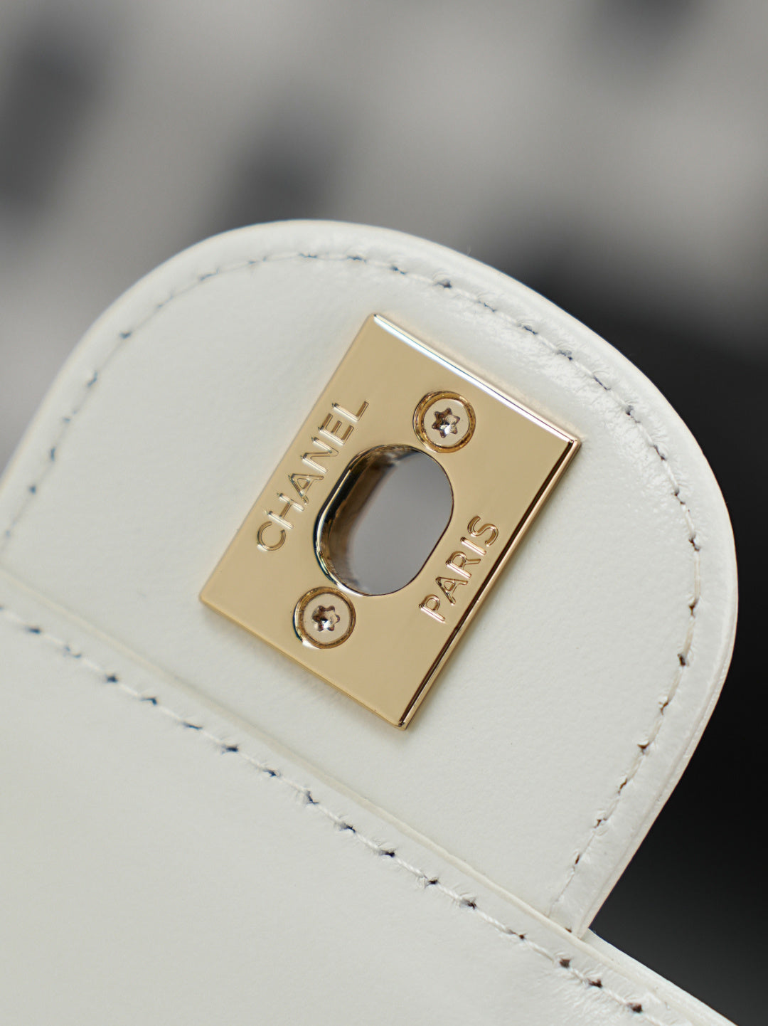 Chanel mini bag strap loop with gold-tone logo plaque and snap closure
