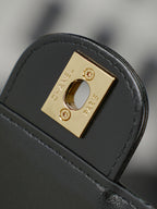 Chanel bag hardware close-up with gold square plate on black leather