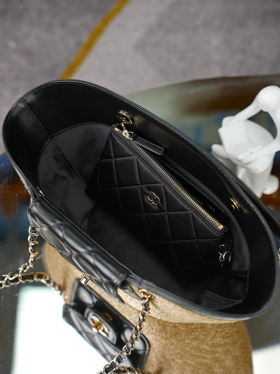 Chanel mini bag interior view with quilted black leather, gold zipper, and chain strap