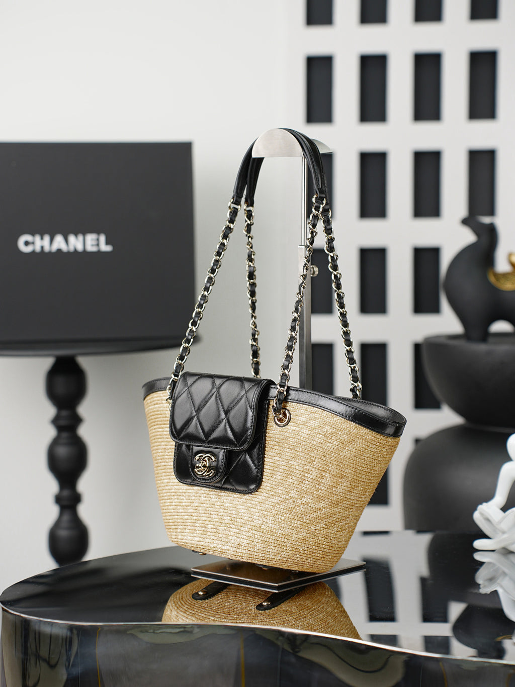 Chanel bag with woven straw body and black leather top, hanging chain handles and quilted mini pouch