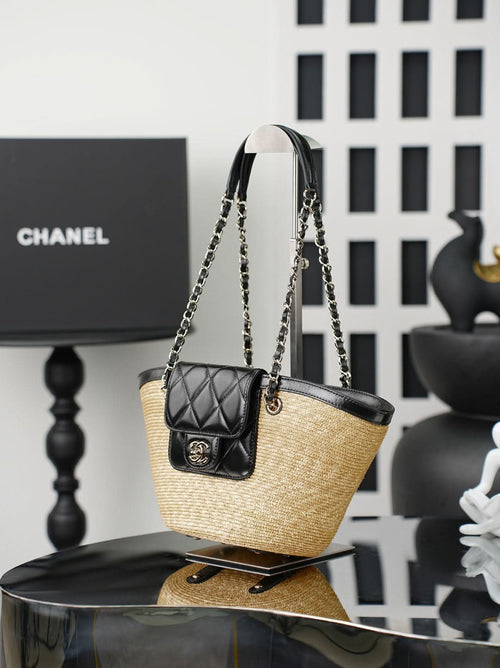 Chanel bag with woven straw body and black leather top, hanging chain handles and quilted mini pouch