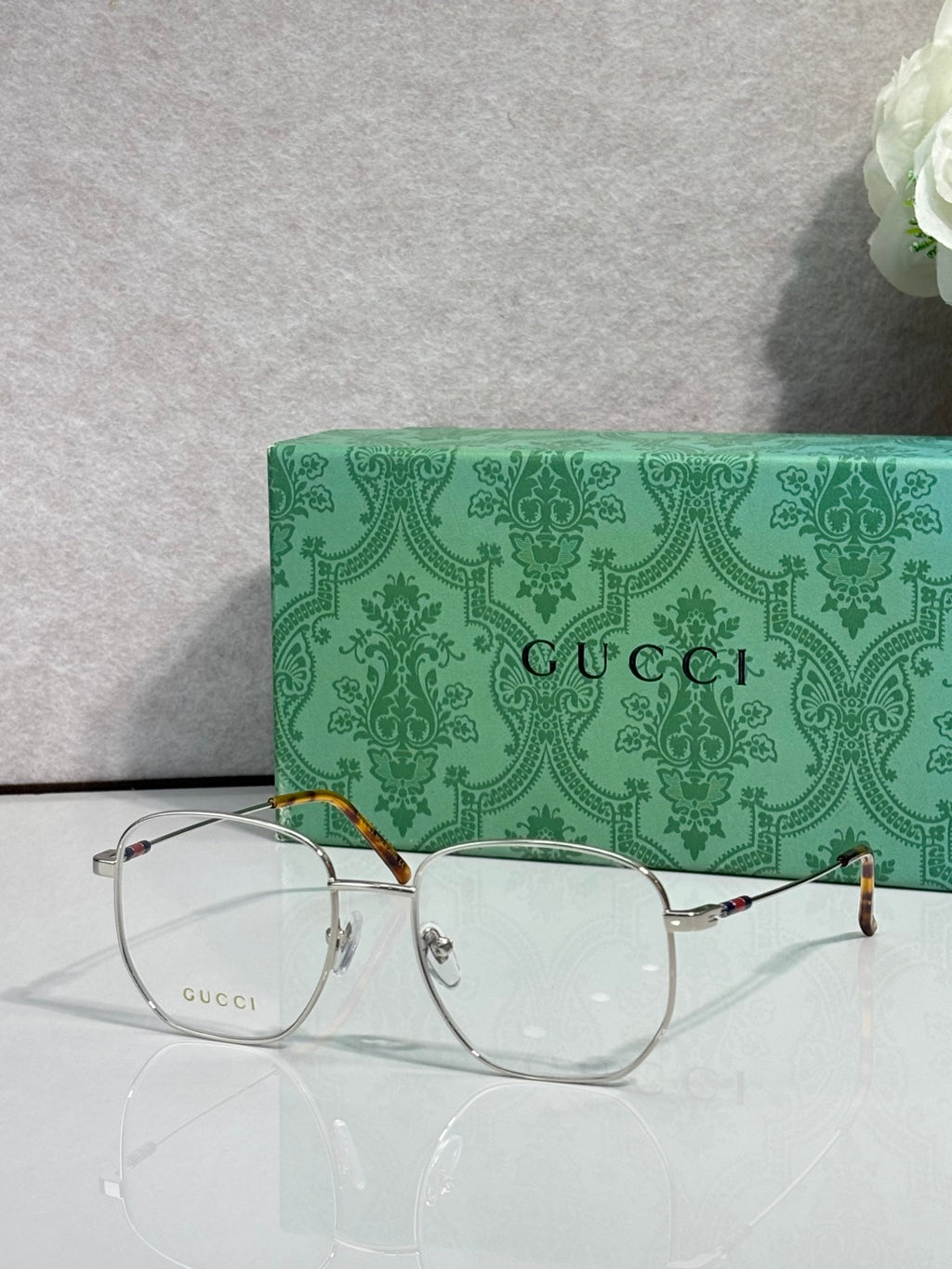 Silver eyeglasses with round clear lenses and gold-tone accents