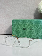 Silver eyeglasses with round clear lenses and gold-tone accents