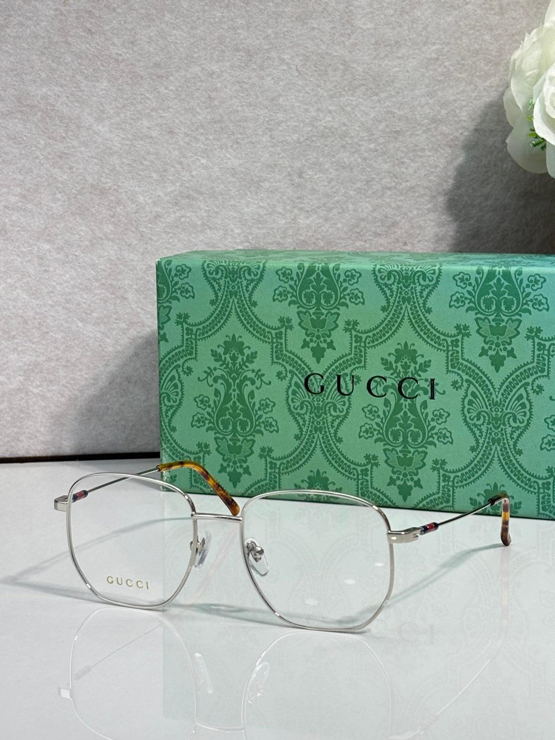 Silver eyeglasses with round clear lenses and gold-tone accents