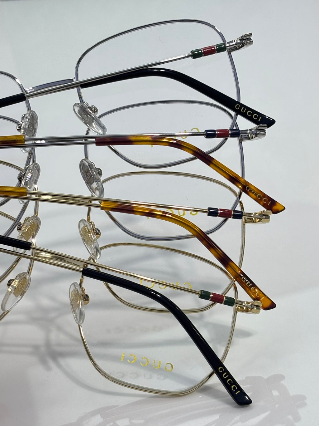 Stacked round metal eyeglass frames with black and amber acetate temples