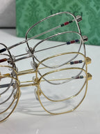 Oval eyeglass frames with clear lenses and gold and silver rims