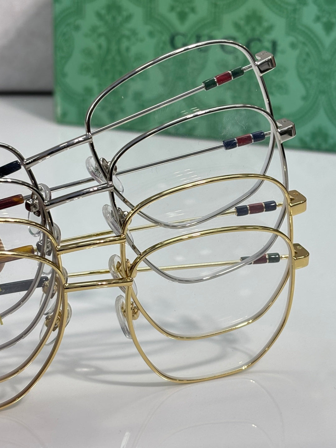 Oval eyeglass frames with clear lenses and gold and silver rims
