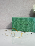 Gucci eyeglasses with gold metal rectangular frames, clear lenses, and tortoise temples