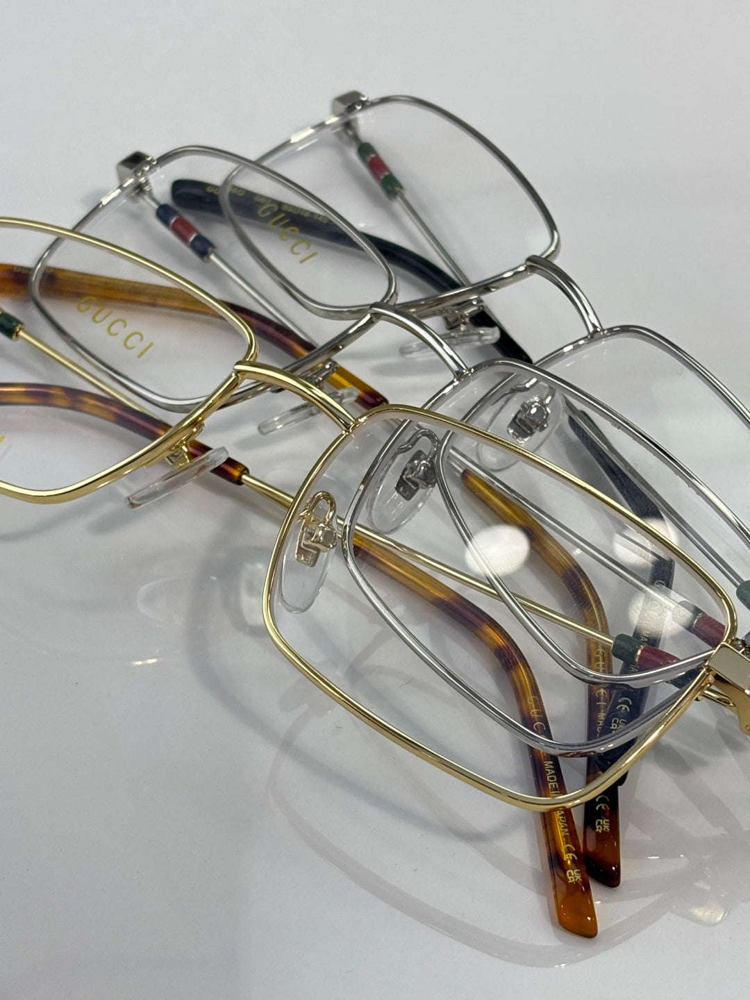 Gucci eyeglasses set with multiple metal frames and clear lenses in silver and gold