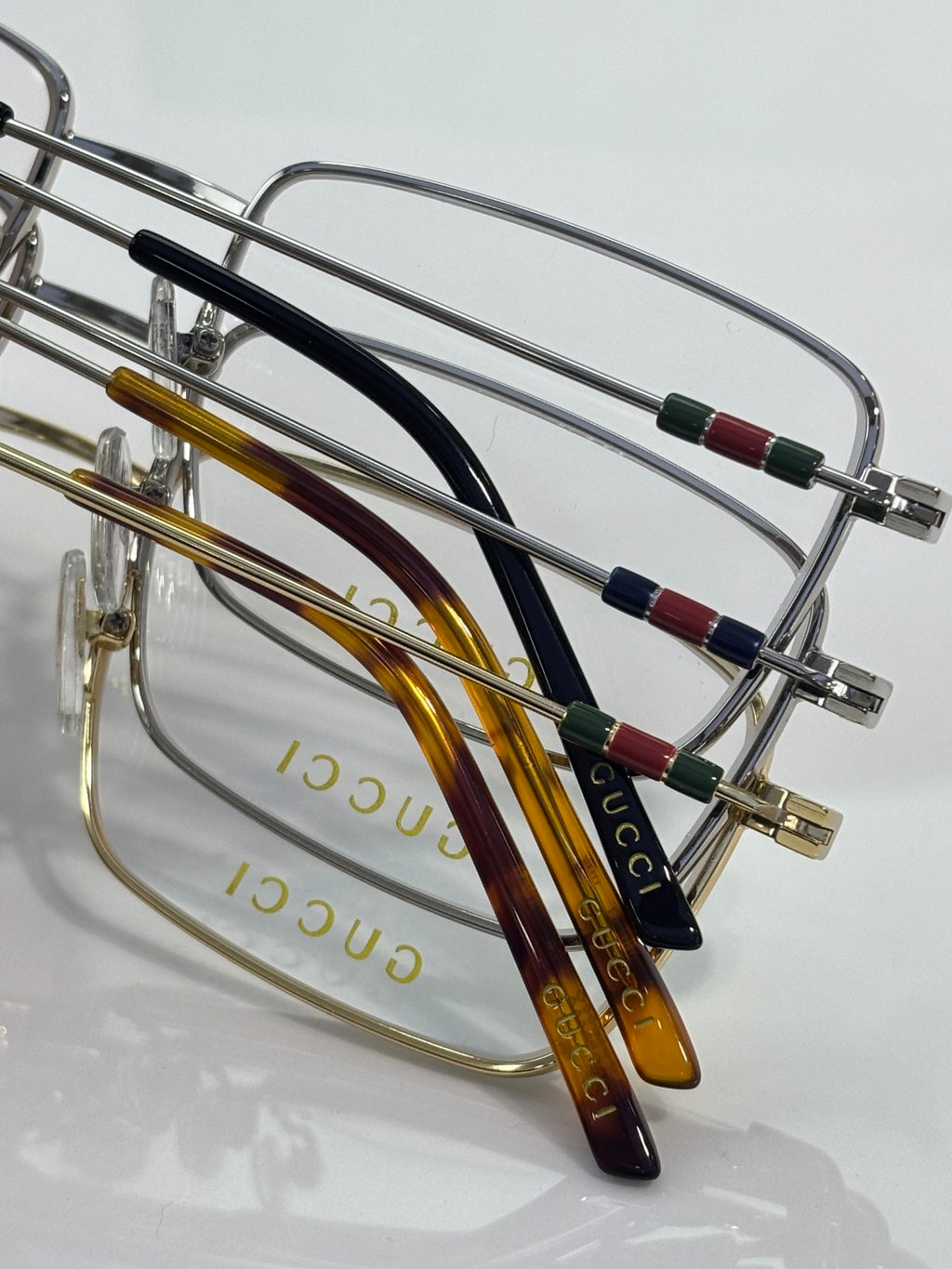 Gucci eyeglasses with curved temples featuring red, green, and blue stripe inlays