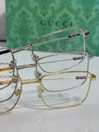 Gucci eyeglasses close-up with gold and silver metal frames and clear lenses