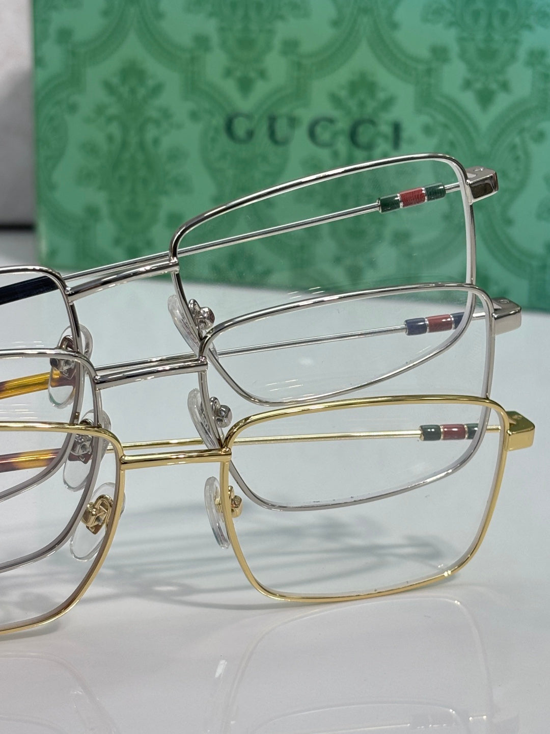 Gucci eyeglasses close-up with gold and silver metal frames and clear lenses