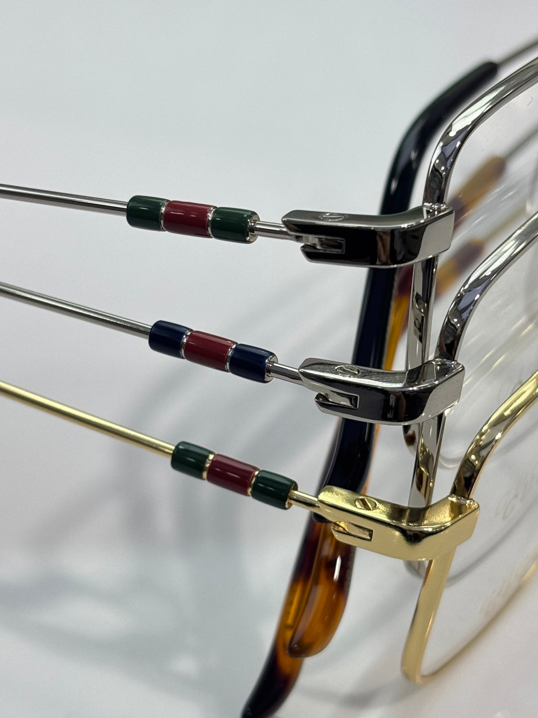 Gucci eyeglasses frame hinge detail with colorful temple inlays in red, green, and blue