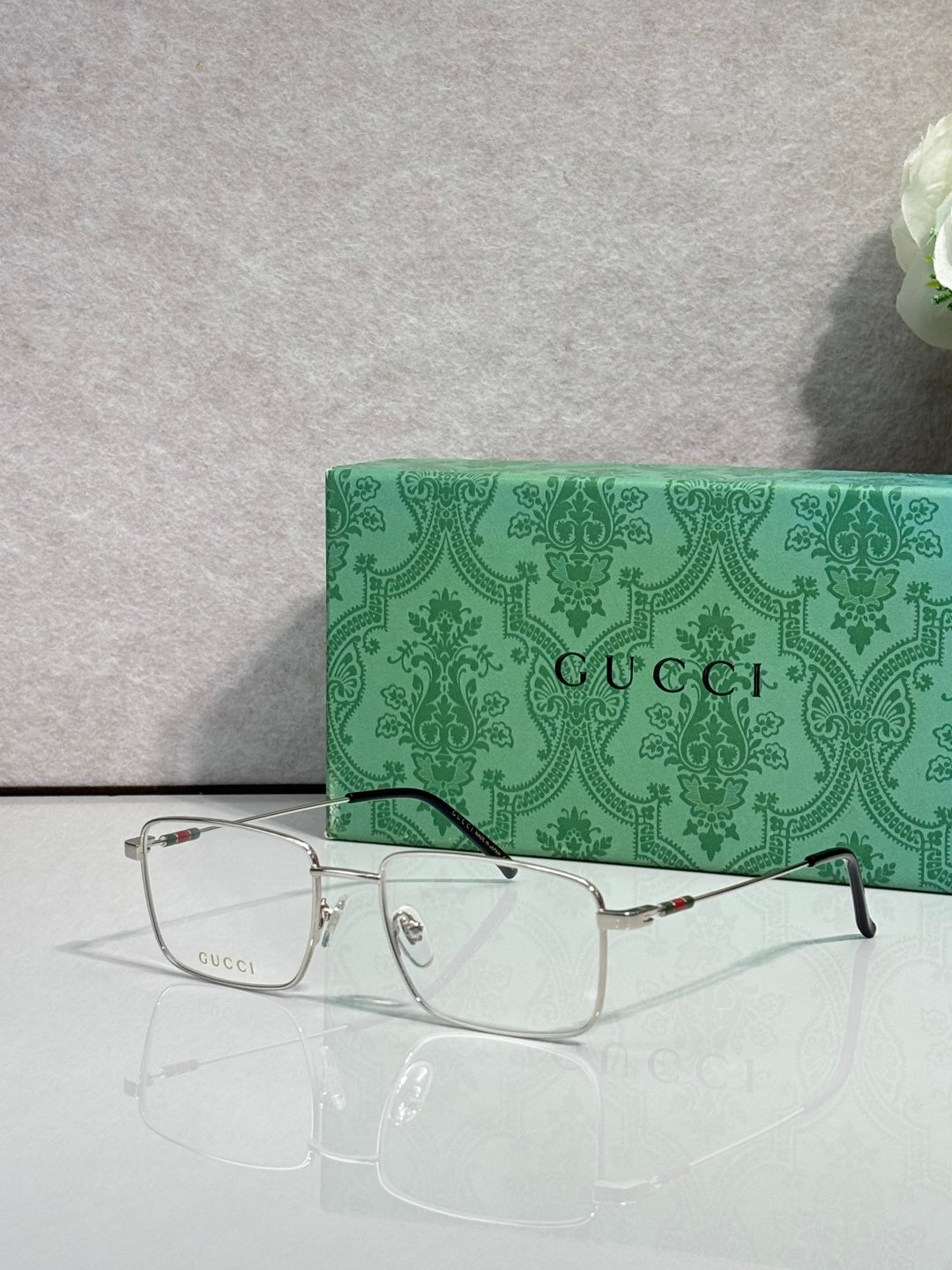 Gucci eyeglasses with silver metal rectangular frames, clear lenses, and tortoise temples