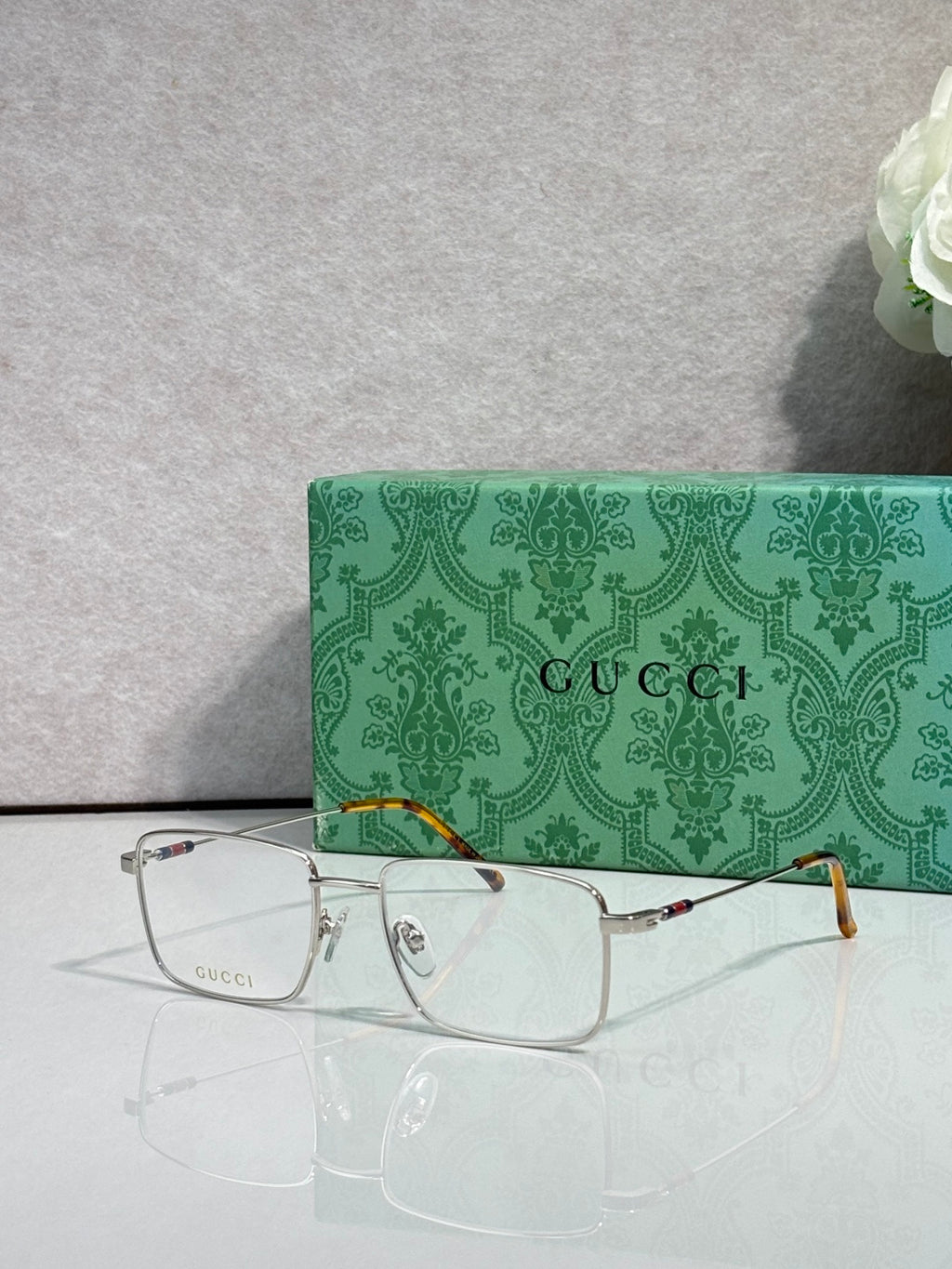 Gucci eyeglasses with silver metal rectangular frames and clear lenses, tortoise temples