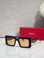 Prada sunglasses with thick black square frames and light tan-tinted lenses; Prada logo on temple