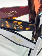 Prada sunglasses close-up of tortoiseshell temples with “PRADA MILANO” text