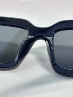 Prada sunglasses close-up: thick dark frames with large square lenses