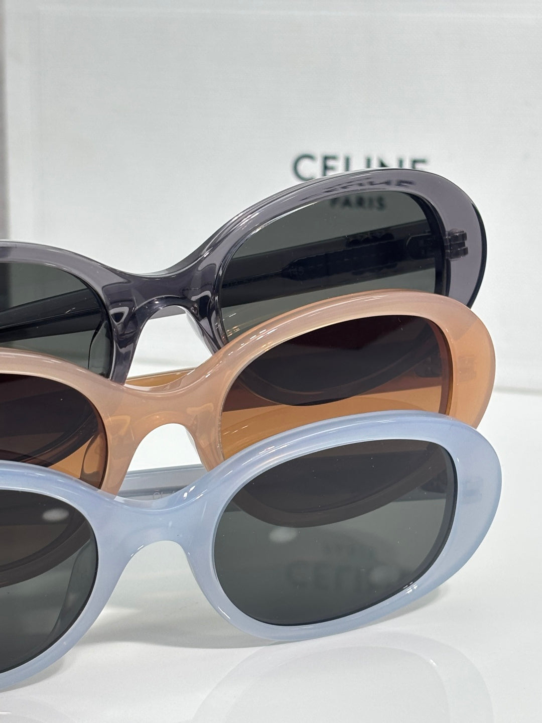 Celine sunglasses with light blue and tan frames, dark lenses, rounded cat-eye style