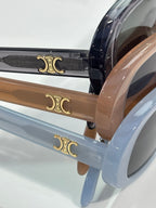 Celine glasses temple close-up with gold Celine emblems on blue and tan frames