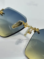 Sunglasses close-up: gold hinge detail with blue gradient lens and black frame