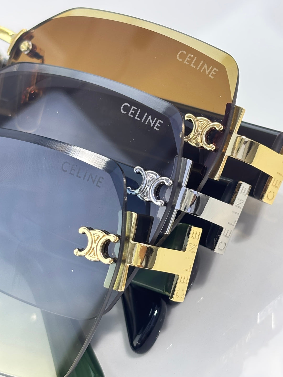Sunglasses close-up with mirrored blue lenses, gold and silver hardware, CELINE text