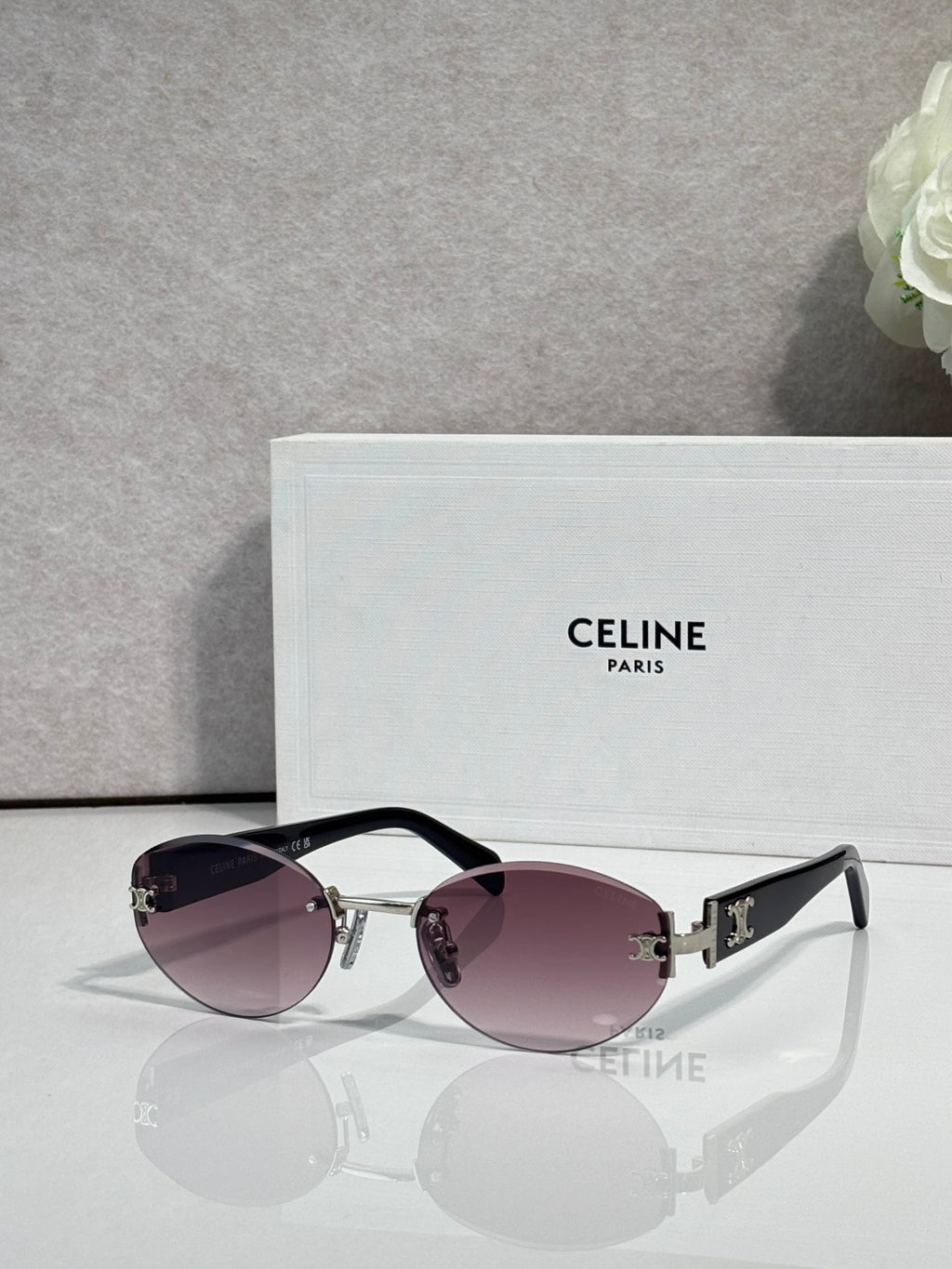 Celine round sunglasses with pink-tinted lenses, black frame arms, and gold details