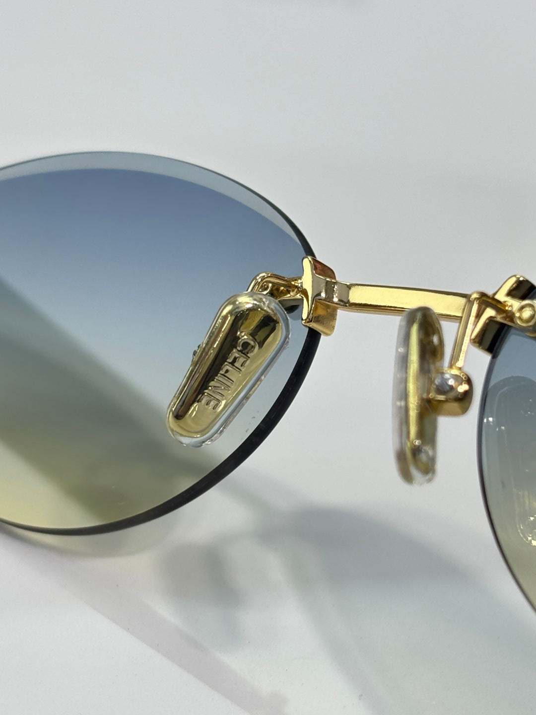 Celine sunglasses close-up of gold hinge and round blue-lens frame