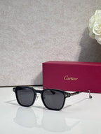 Cartier eyeglasses with black frames and dark tinted lenses