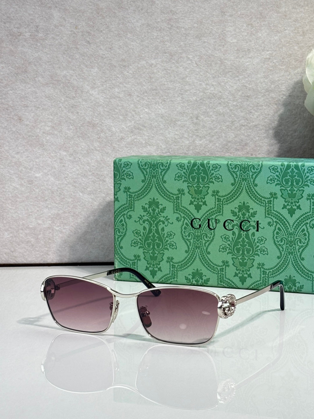 Gucci glasses with silver-tone frame and rose-tinted gradient lenses.