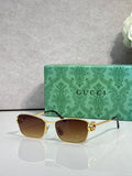 Gucci glasses with gold-tone frame and dark brown gradient lenses.