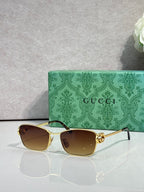 Gucci glasses with gold-tone frame and dark brown gradient lenses.