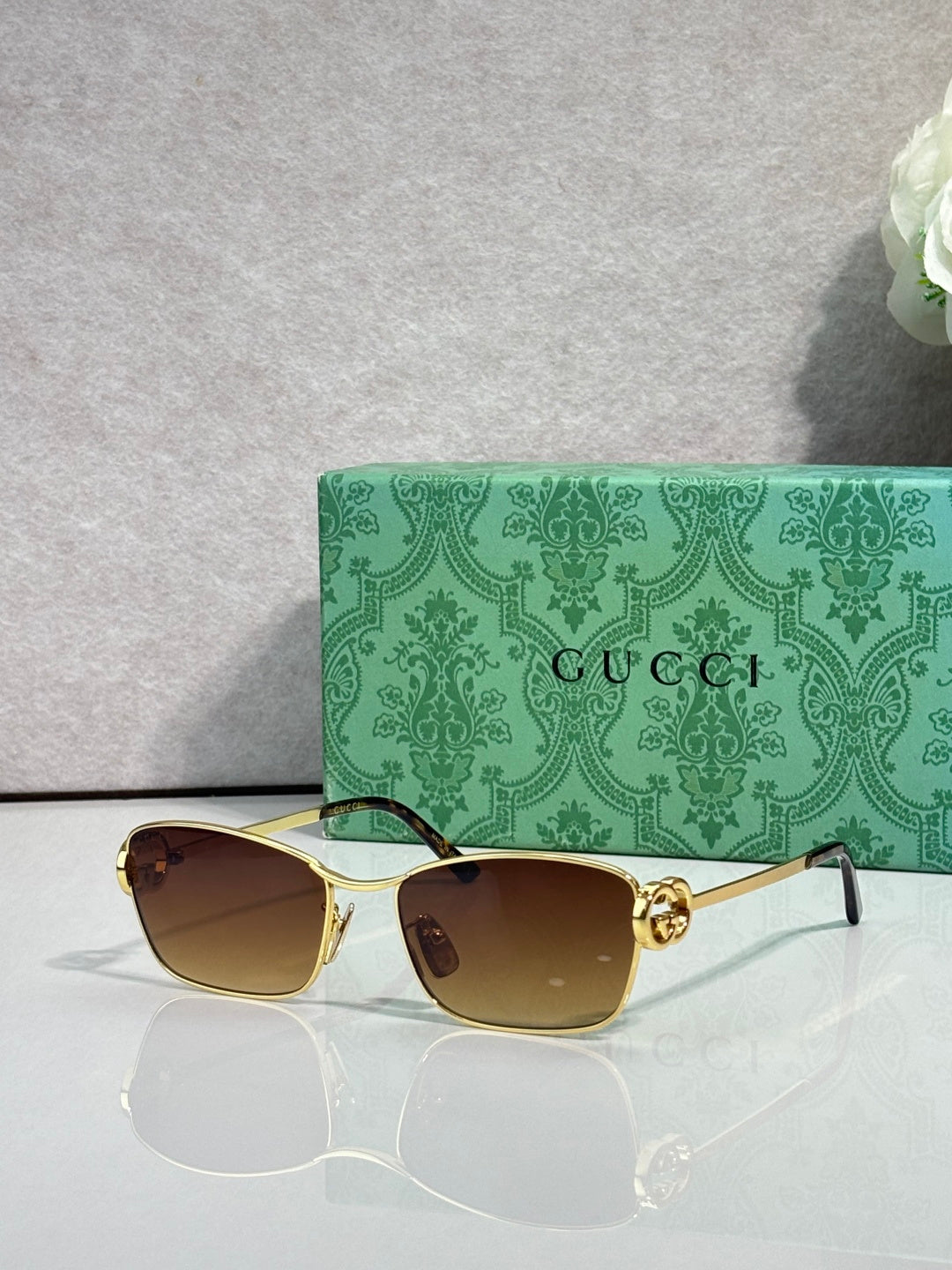 Gucci glasses with gold-tone frame and dark brown gradient lenses.